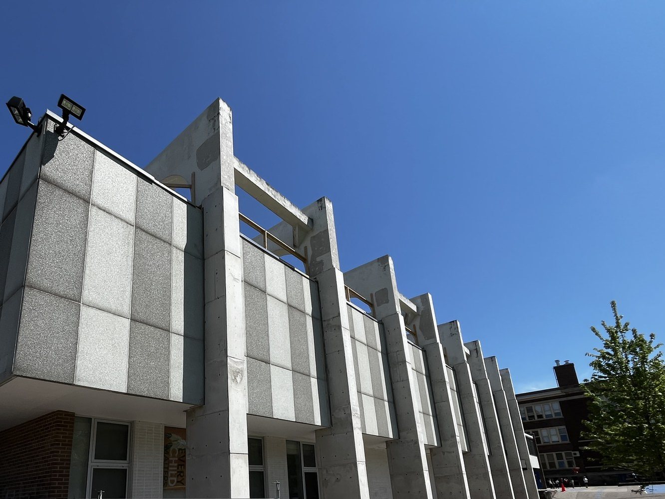 The repeating concrete roof frames along the gym